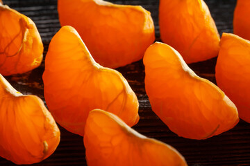 sliced tangerine on black wood background