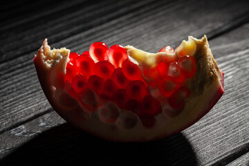 sliced pomegranate on black wood background