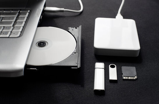 data storage devices connected to a laptop, data security, digital data storage, laptop open optical drive with disk