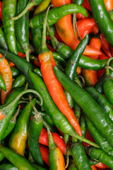 Green and red chili pappers. Selective focus. Vertical mode.