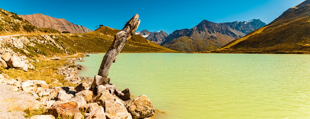 High resolution stitched alpine summer panorama with a wooden fish at Lake Rifflsee, Mandarfen,...
