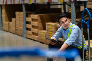 Asian warehouse worker who is tired from work. Being fired from work. Unemployed. Failed. Hopeless....