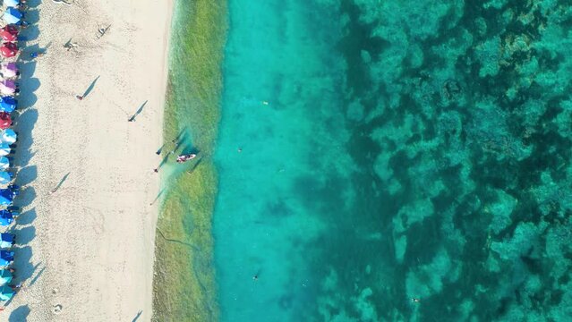 Aerial top view of Pantai Pandawa beach in Bali with clear sea waterand and white sand beach.