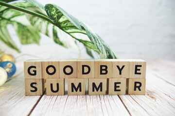 Goodbye Summer alphabet letter with Monstera leave decoration on wooden background