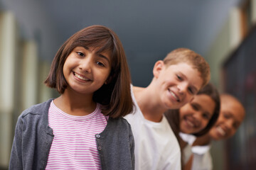 Girl, portrait and friends in row at school with confidence and pride for learning, education or knowledge. Student, people and face with smile in building or hallway before class or ready to study