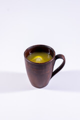 hot citrus lemon drink in clay cup on white background isolated