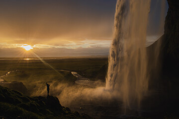 Scenic view of waterfall against sky during sunset at golden hour
