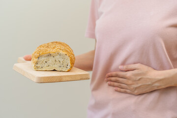 Gluten allergy woman hand holding, refusing to eat white loaf slice on board in breakfast food meal...