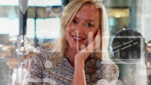 Animation of media icons and binary coding over caucasian woman in cafe