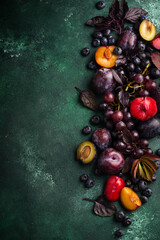 Assortment of purple fruit plum, grape, blueberry and basil