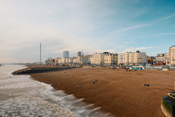 Brighton at sunset with rocky beach and buildings.