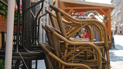 Outdoor Chairs and Tables Stacked and Secured for Night with Metal Steel Cable and Padlock In front of Boulveard Pub Cafe Coffee Shop Before Opening Hours