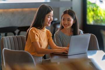 Weekend Out-of-Office Collaboration. Two young Asian woman break away from the office, opting for a cozy café to discuss work. 