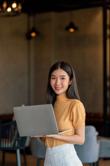 Young asian woman working on laptop at a remote workplace