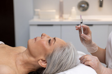 Obraz na płótnie Canvas Close up of woman having hair treatment injections