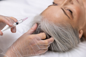 Mature woman having filler injections at beauty clinic