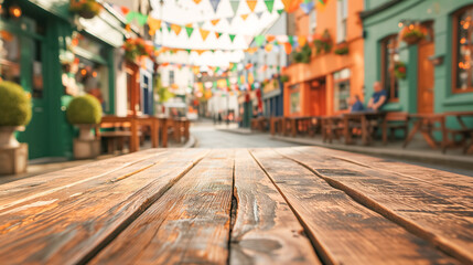 Wooden empty tabletop on blurred city street background with green holiday garlands and St. Patrick's Day flags - obrazy, fototapety, plakaty