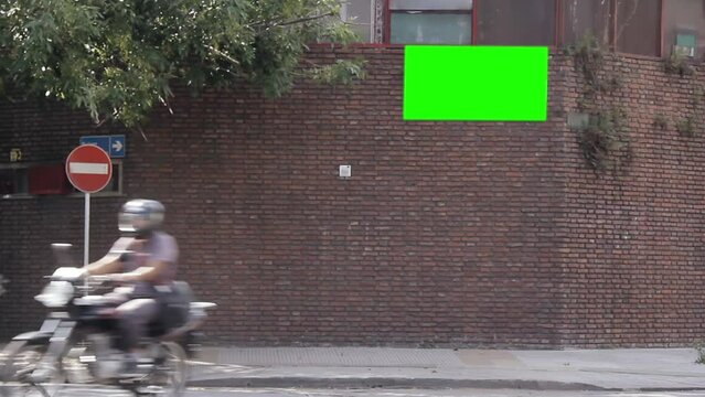 Billboard Green Screen Hanging From Brick Wall in Buenos Aires, Argentina. You can replace green screen with the footage or picture you want with “Keying” effect in After Effects.