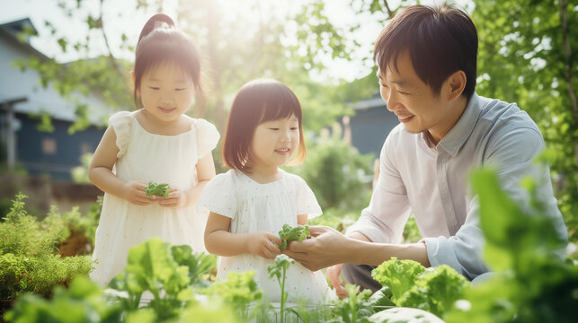Happy family planting vegetables together in the garden at home, asian