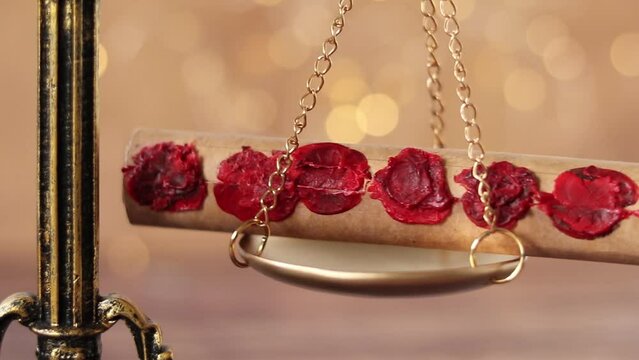 Ancient seven seal scroll swinging on golden balance scale with bokeh light background. Close-up. Christian concept of prophecy, justice, judgment, and revelation of God Jesus Christ.