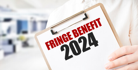 Text FRINGE BENEFIT 2024 on white paper plate in businessman hands in office. Business concept
