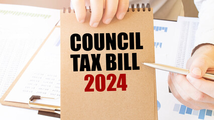 Text COUNCIL TAX BILL 2024 on brown paper notepad in businessman hands on the table with diagram. Business concept - obrazy, fototapety, plakaty