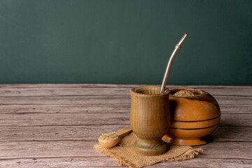 Mate tea: Traditional South American caffeine-rich infused drink, with grass over table of wood 