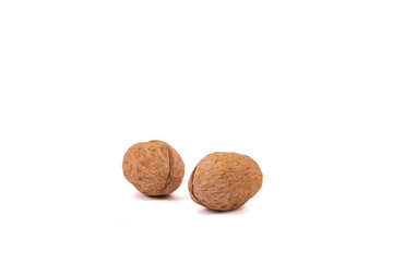 Scattered whole walnuts lie on a white background. Backgrounds and textures. Isolate.