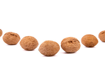 Scattered whole walnuts lie on a white background. Backgrounds and textures. Isolate.