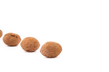 Scattered whole walnuts lie on a white background. Backgrounds and textures. Isolate.