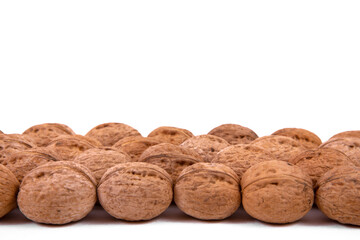 Scattered whole walnuts lie on a white background. Backgrounds and textures. Isolate.