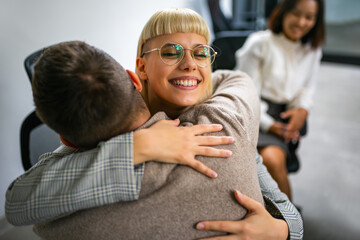 Business people hugging at a group therapy session, overcoming problem together