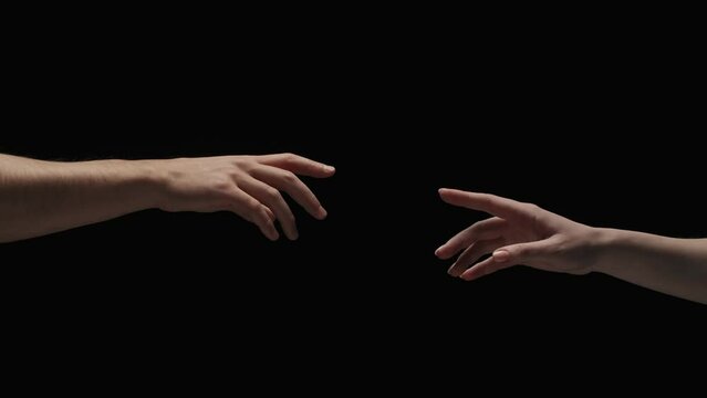Portrait of models hands isolated on black background. Man and woman naked hands lending to each other and touch fingers.