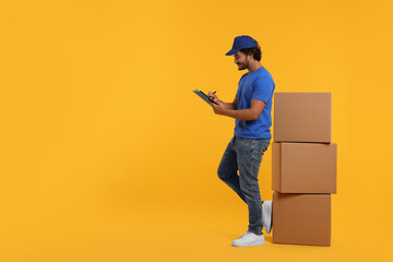 Happy courier with clipboard and stack of parcels on orange background, space for text