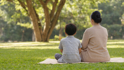 mother and son sitting in peaceful park 