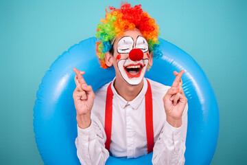 Funny clown and different situations. A happy guy is waiting for a vacation. Blue background.