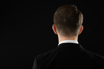 Man on black background, back view. Space for text