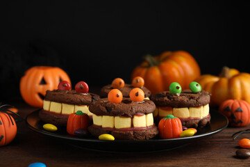 Delicious desserts decorated as monsters on wooden table. Halloween treat