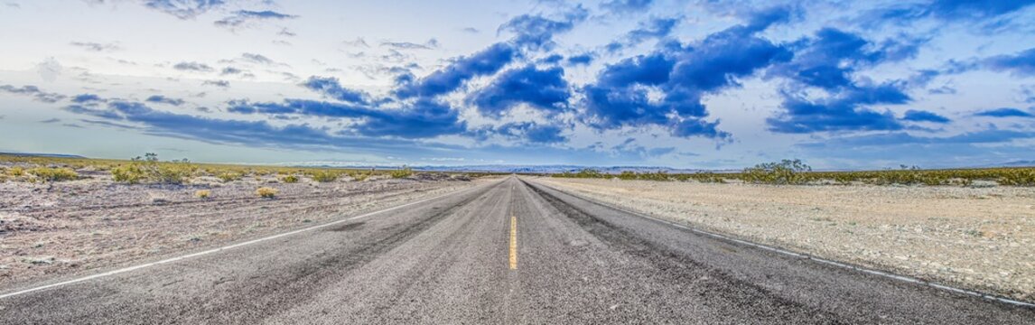 Panoramic picture of a lonely road through mountainous desert