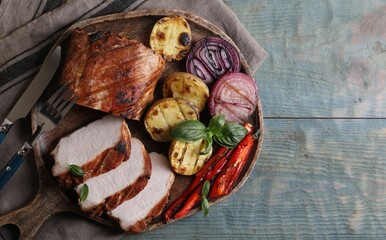 Delicious grilled meat and vegetables served on wooden table, top view. Space for text