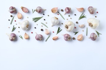 Fresh garlic, rosemary and peppercorns on white background, flat lay. Space for text