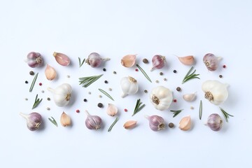 Fresh garlic, rosemary and peppercorns on white background, flat lay