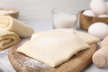 Fototapeta na wymiar Raw puff pastry dough on table, closeup