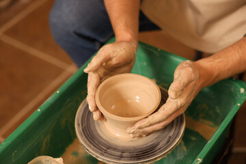 Clay crafting. Man making bowl on potter's wheel, closeup