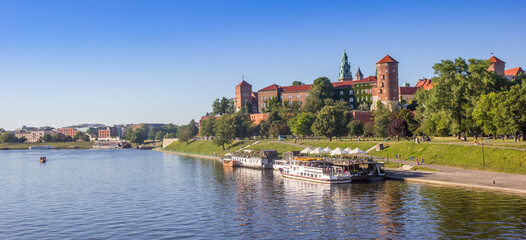 Panorama over the Vistula river with ship and the Wawel castle in Krakow, Poland