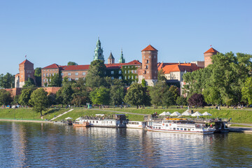 Fototapeta premium Restaurant ships in the river at the historic Wawel castle in Krakow, Poland