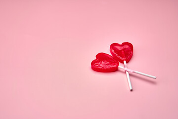 Two red sweet tasty lollipops in shape of heart.