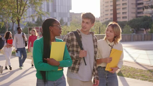 Group of multiracial young students walking and smiling and happy looking at camera in a university campus. Lifestyle Generation z friends having fun together outdoor. International people daily life