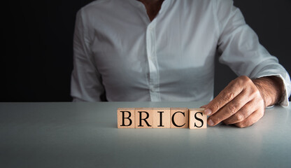 hand posing wooden blocks with BRICS, Acronym for Brazil, Russia, India, China (PRC), and South...
