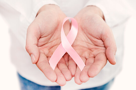 Hand holding pink breast cancer awareness ribbon